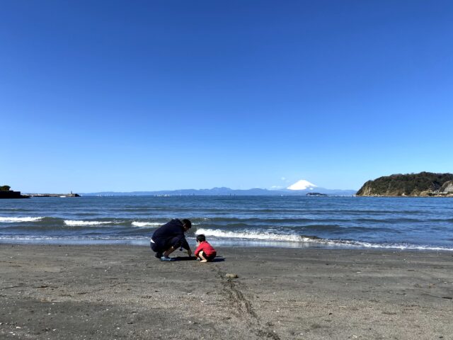 逗子海岸で子供と砂遊びしている写真